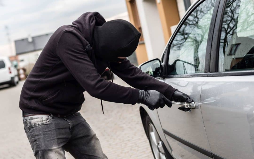 A thief breaks into the car of someone who doesn't know how to prevent car theft.
